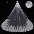 Long lace wedding veil in white with intricate floral embroidery and a delicate flower accent for bridal wear