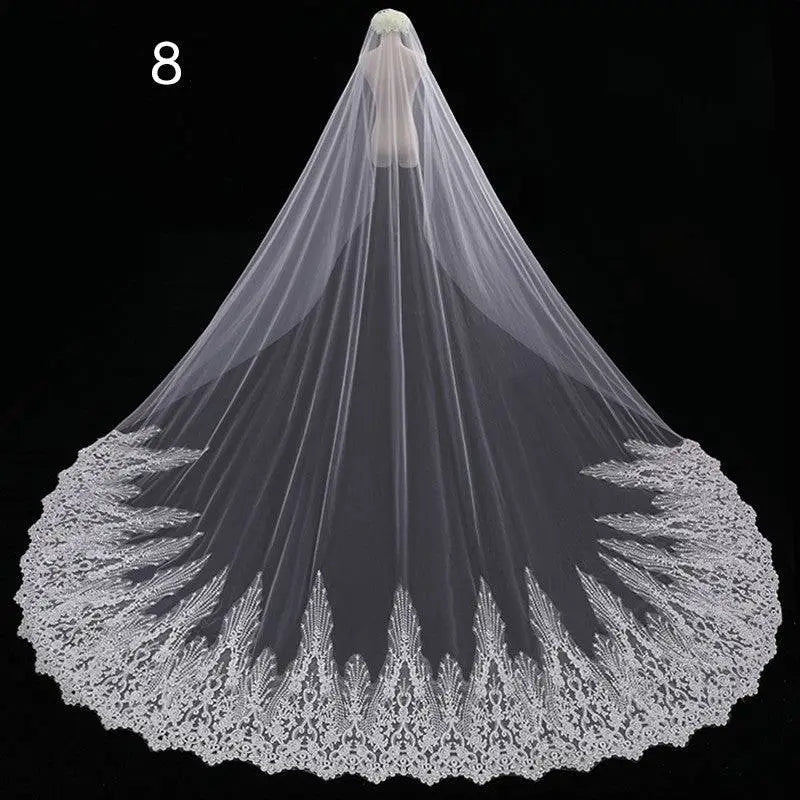 Long lace wedding veil in white with intricate floral embroidery and delicate scalloped edge design