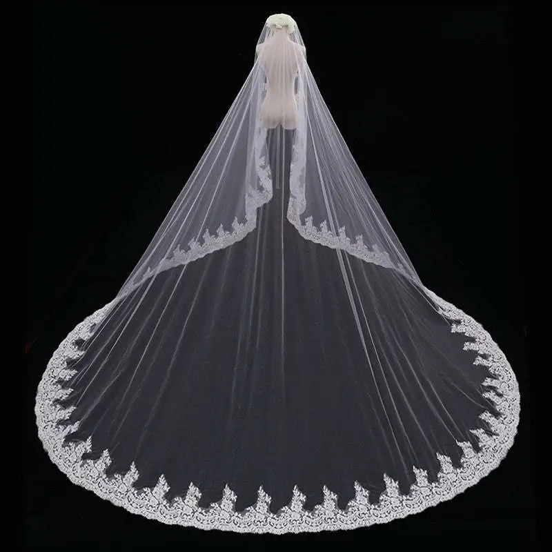 Long lace wedding veil meters wide with delicate white lace and intricate floral embroidery draped over a mannequin