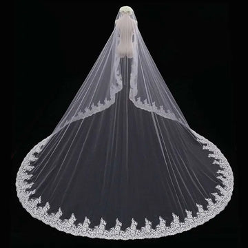 Long lace wedding veil meters wide with delicate white lace and intricate floral embroidery draped over a mannequin