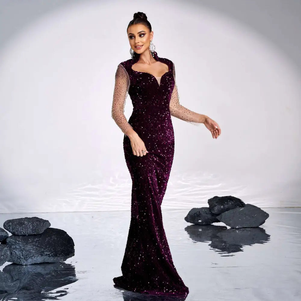 A deep purple long sleeve banquet sequined rhinestone fishtail gown with sheer mesh sleeves and sparkling details