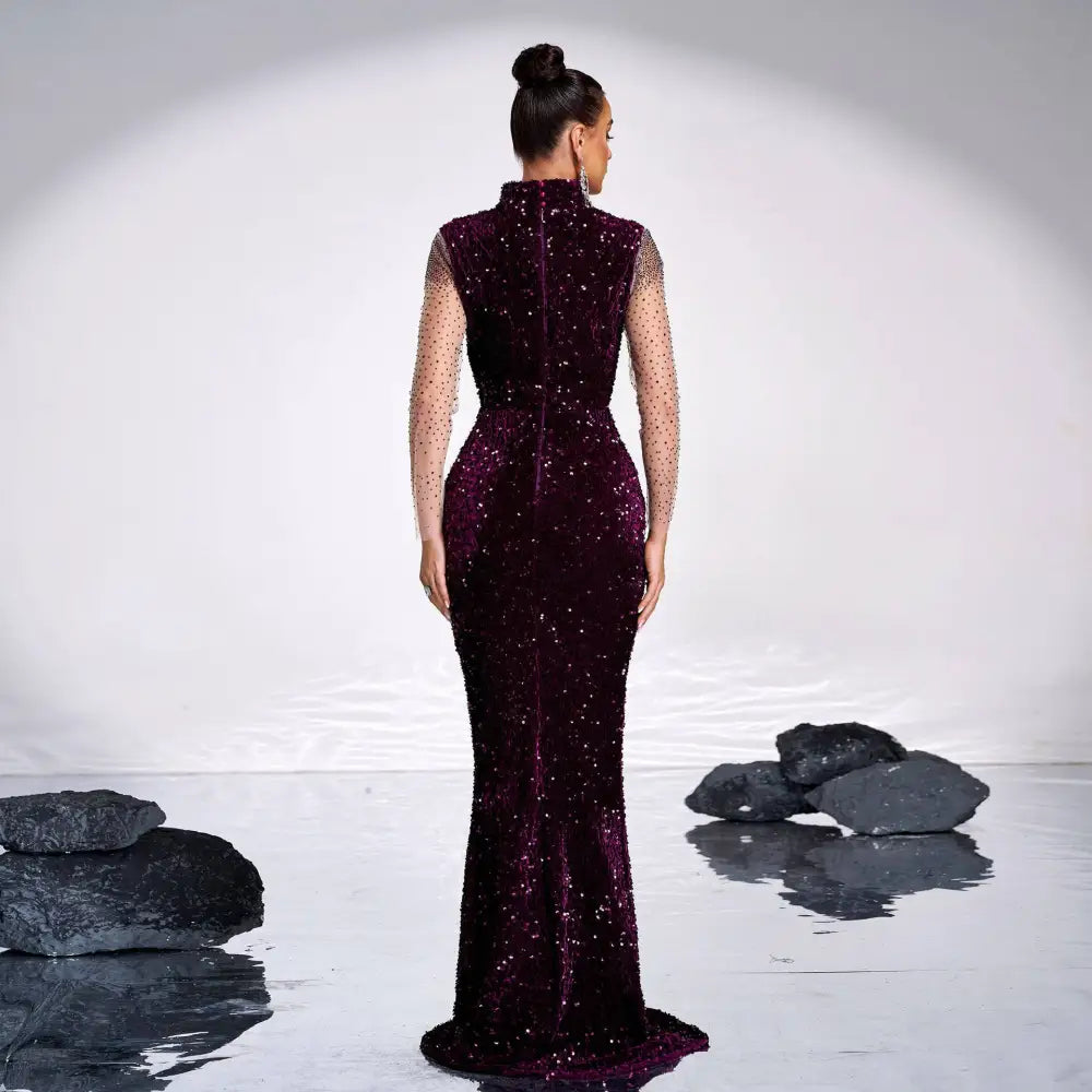 A deep purple long sleeve banquet sequined rhinestone fishtail gown in shimmering burgundy velvet with sheer dotted sleeves