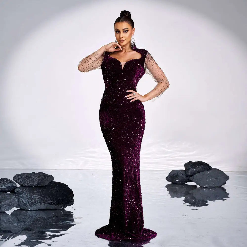 A deep purple long sleeve banquet sequined rhinestone fishtail gown with sheer mesh sleeves and a shimmering finish