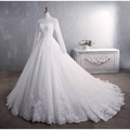 Elegant white lace wedding dress with long sleeves high neckline and intricate floral embroidery for bridal gown