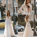 A delicate white long sleeve wedding dress lace gown with a deep v neckline and flowing skirt