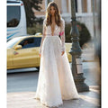 A delicate white long sleeve wedding dress lace gown with a deep v neckline perfect for bridal wear