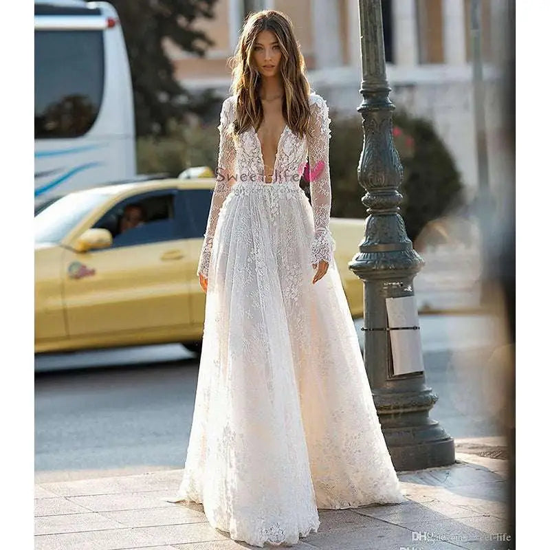 A delicate white long sleeve wedding dress lace gown with a deep v neckline perfect for bridal wear