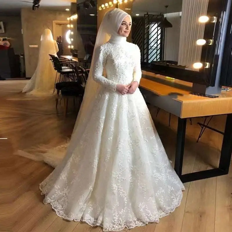Long sleeve white dignified wedding dress featuring high neckline and intricate floral lace embroidery on bodice and skirt
