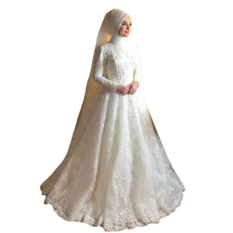 A dignified wedding dress featuring a flowing white lace fabric with long sleeves and a high neckline with floral embroidery