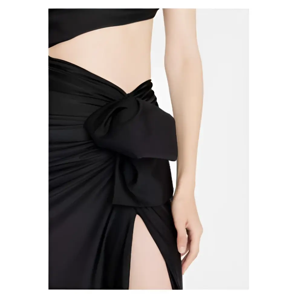 Black satin wrap skirt with prominent bow at the waist paired with black long sleeved elastic shoulder dress featuring hollow slit
