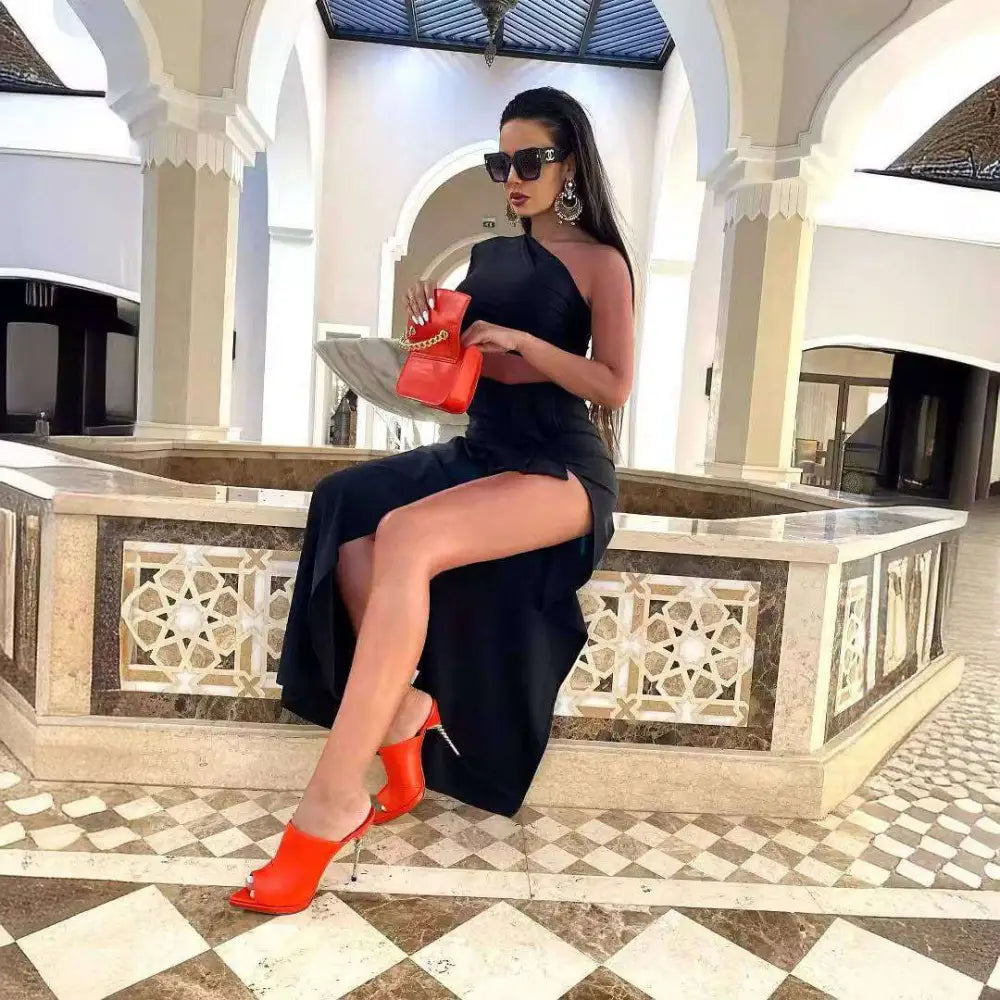 Vibrant red handbag with gold chain strap paired with black long sleeved hollow slit elastic shoulder dress