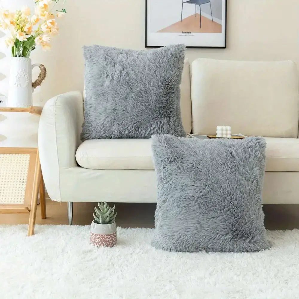 Two plush light gray luxurious soft faux fur throw pillow covers with a soft fluffy texture for cushion covers