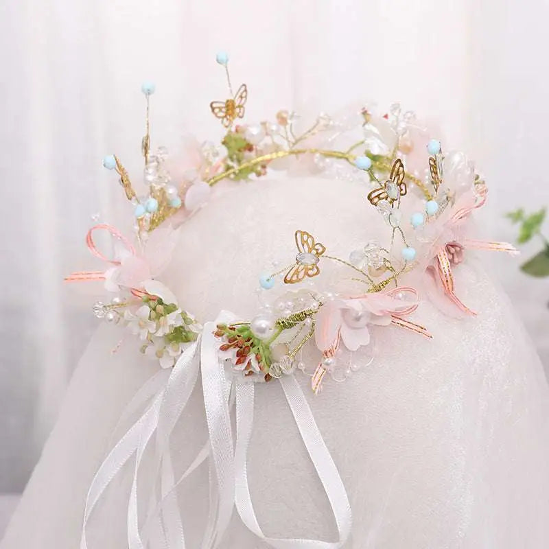 Luxury floral bridal wreath featuring delicate pink flowers gold butterfly charms pearls and sheer ribbons for brides