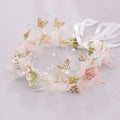 Luxury floral bridal wreath featuring delicate pink and white fabric flowers with gold butterfly charms and pearl accents