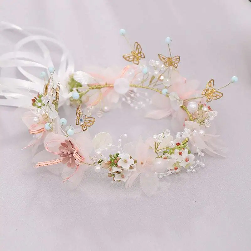 Luxury floral bridal wreath featuring delicate pink and white fabric flowers with gold butterfly charms and pearl beads