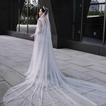 A long white industry bridal pearl veil with scattered pearl-like beads and a sparkling tiara for luxury weddings