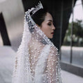 A luxury heavy industry bridal pearl tiara with intricate crystal details and a cascade of scattered pearl-like beads