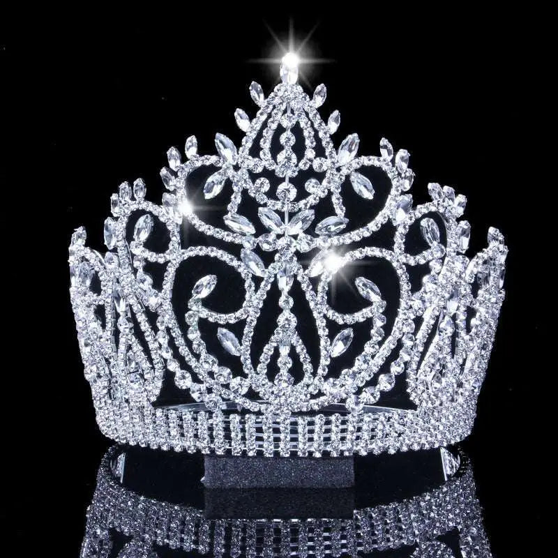 A sparkling silver bridal crown with intricate crystal embellishments and a central radiant starburst accent