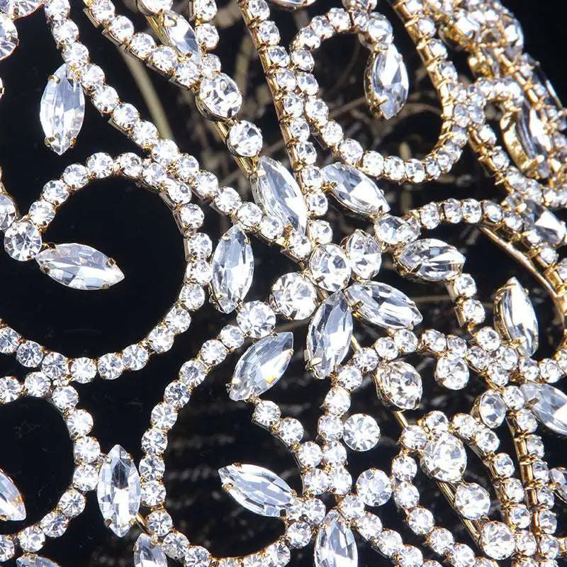 A sparkling silver bridal crown with intricate crystal embellishments and a central radiant starburst accent