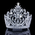 A sparkling silver bridal crown with intricate crystal embellishments and a central starburst accent for luxury wear