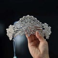 A luxury silver forehead crown with intricate crystal and pearl rhinestone wedding dress embellishments