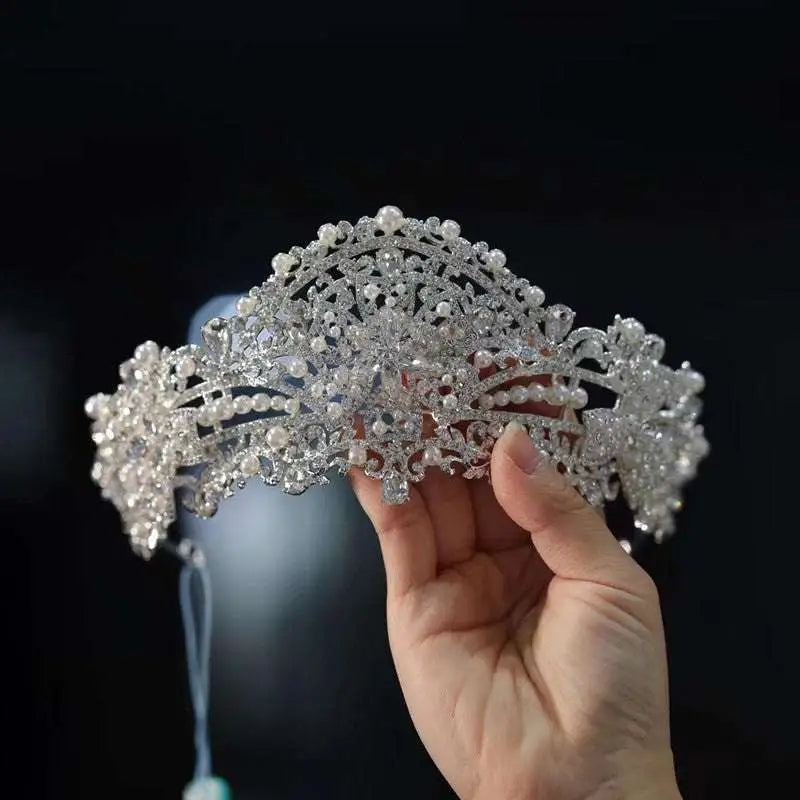 A luxury silver forehead crown with intricate crystal and pearl rhinestone wedding dress embellishments