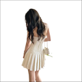 A cream-colored, sleeveless luxury women’s fashion tweed mini dress with a corset-style back detail
