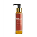 A sleek amber glass bottle with gold pump dispenser labeled magic luxury body oil in elegant white lettering