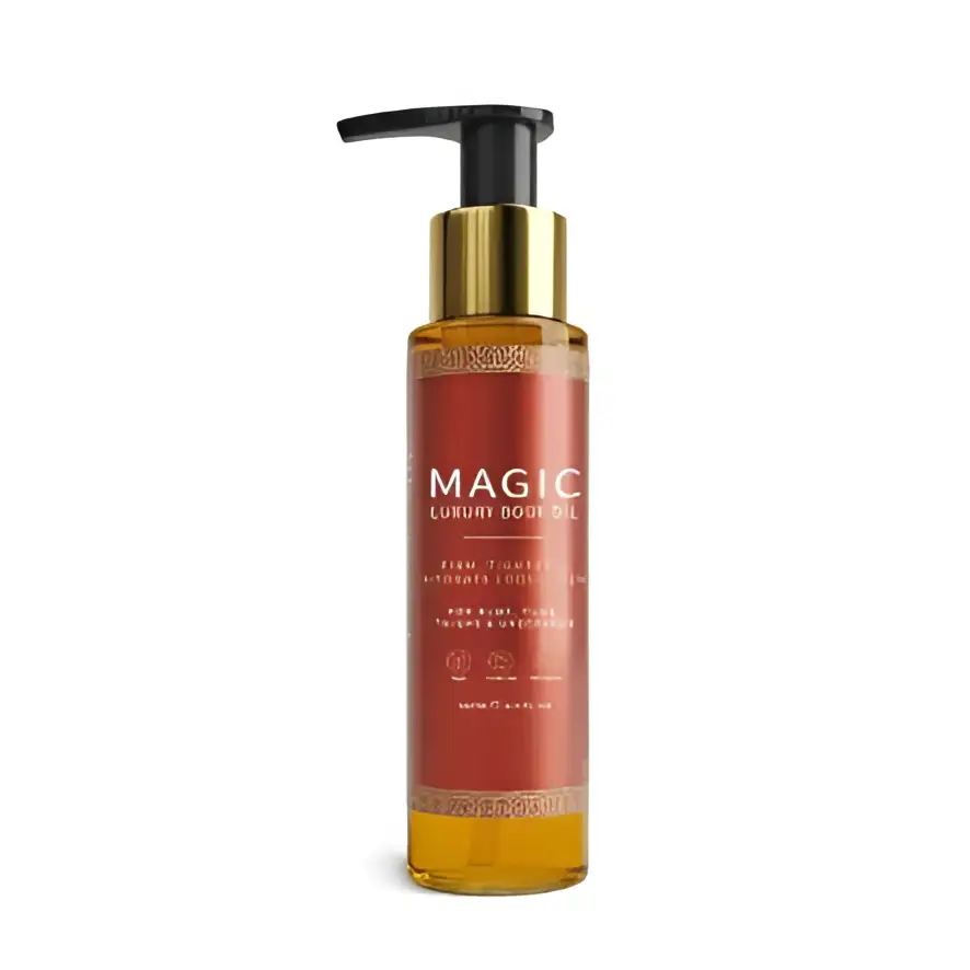 A sleek amber glass bottle with gold pump dispenser labeled magic luxury body oil in elegant white lettering