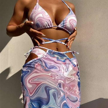 A flowing bikini 3-piece beach skirt set with a vibrant marbled pink and blue pattern in lightweight fabric