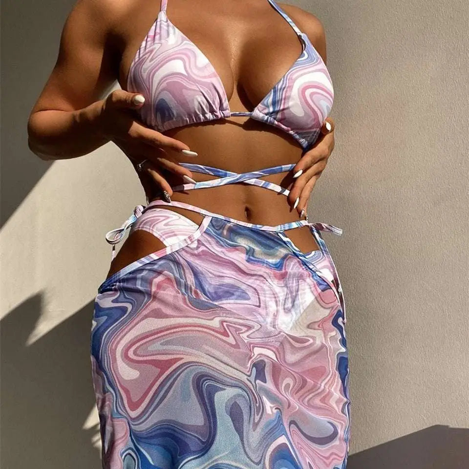 A flowing bikini 3-piece beach skirt set with a vibrant marbled pink and blue pattern ideal for beachwear