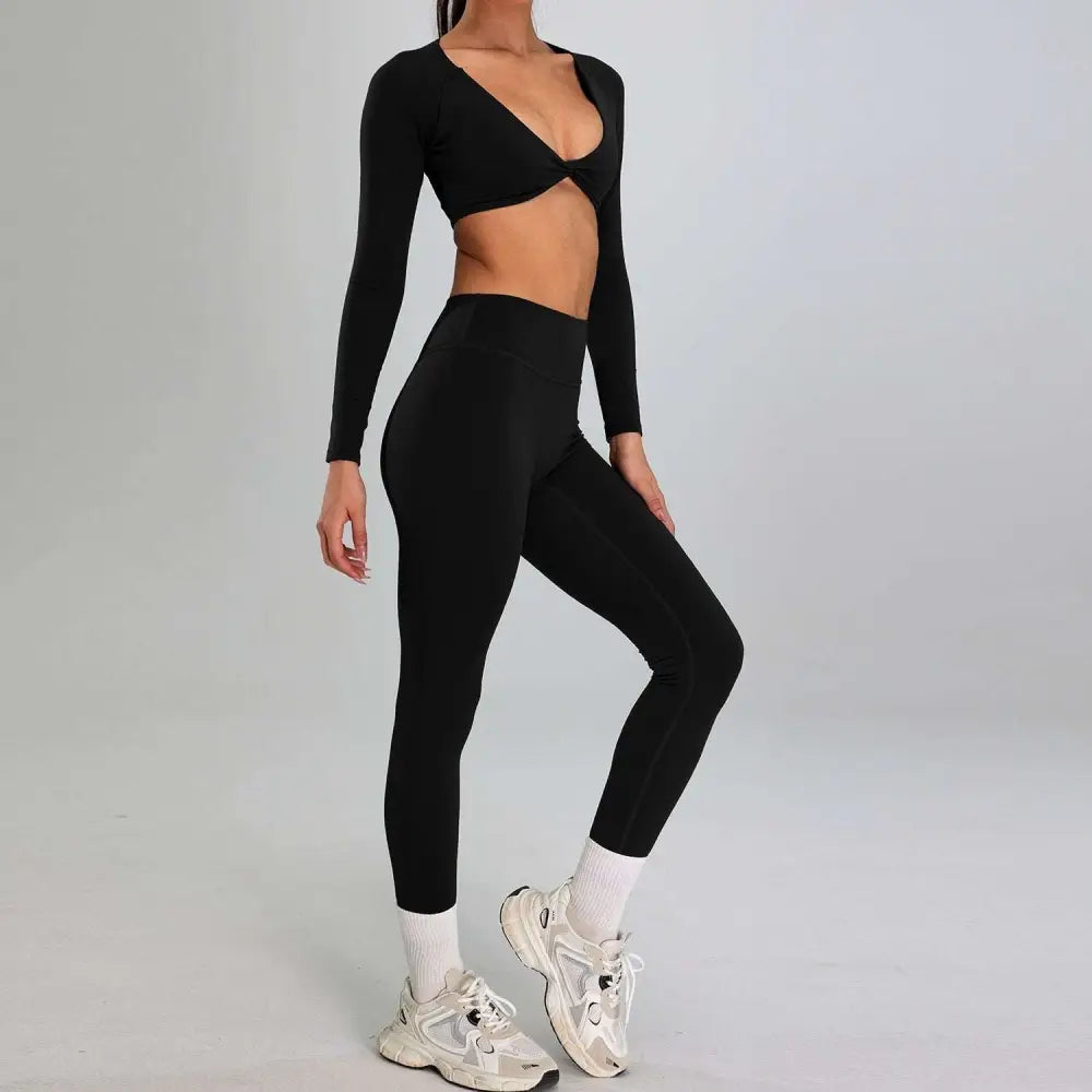 Black long-sleeved crop top with deep v-neck and front twist paired with matching high waist suit for outdoor running nude set