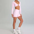 A soft pink long-sleeved crop top with v-neck and side cutouts from a maroon high waist suit running nude set