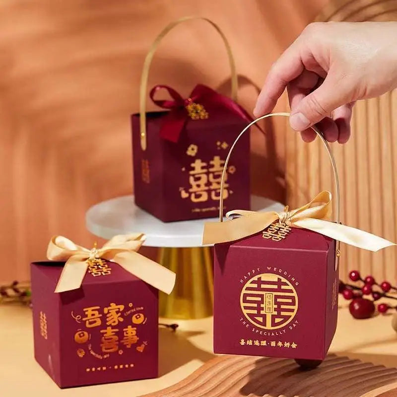 Maroon minimalist wedding candy gift box with gold handle and bow featuring golden chinese double happiness characters