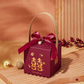 Maroon minimalist wedding candy gift box with gold handle and red satin bow featuring golden double happiness characters