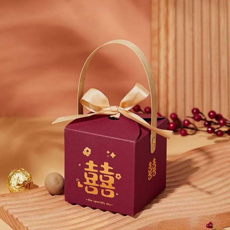 Maroon minimalist wedding candy gift box with gold handle and bow featuring golden chinese double happiness characters
