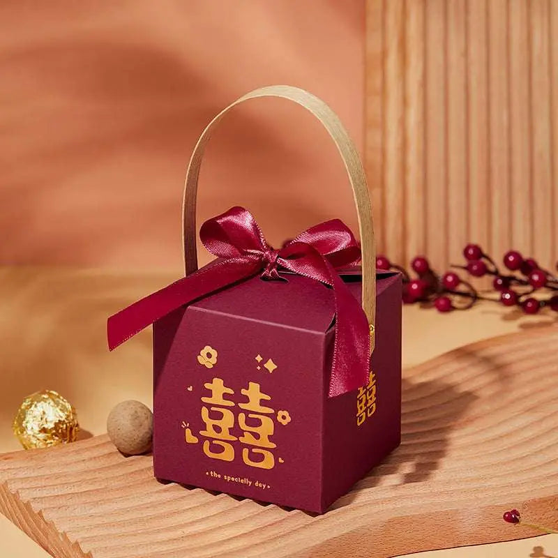 Maroon minimalist wedding candy gift box with gold double happiness symbol, bamboo handle, and decorative ribbon