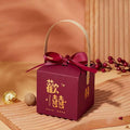 Maroon minimalist wedding candy gift box with gold Chinese characters, matching ribbon bow, and light wood handle