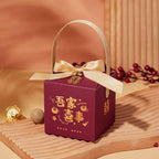 Maroon minimalist wedding candy gift box with gold satin ribbon bow handle and golden chinese decorative motifs