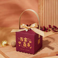 Maroon minimalist wedding candy gift box with gold foil lettering, satin ribbon bow, pearl, and gold handle