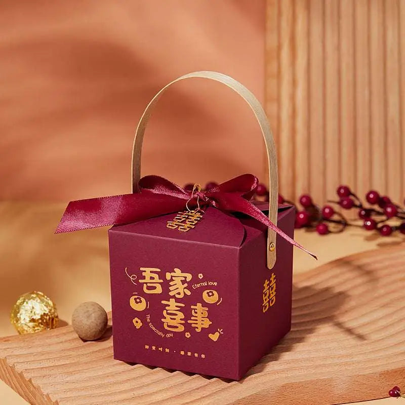 Maroon minimalist wedding candy gift box with gold chinese characters, matching ribbon bow, and light wood handle