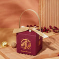 Maroon minimalist wedding candy gift box with gold handle featuring embroidered double happiness symbol and golden text