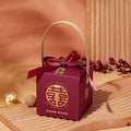 Maroon minimalist wedding candy gift box with gold handle and ribbon bow featuring golden chinese characters