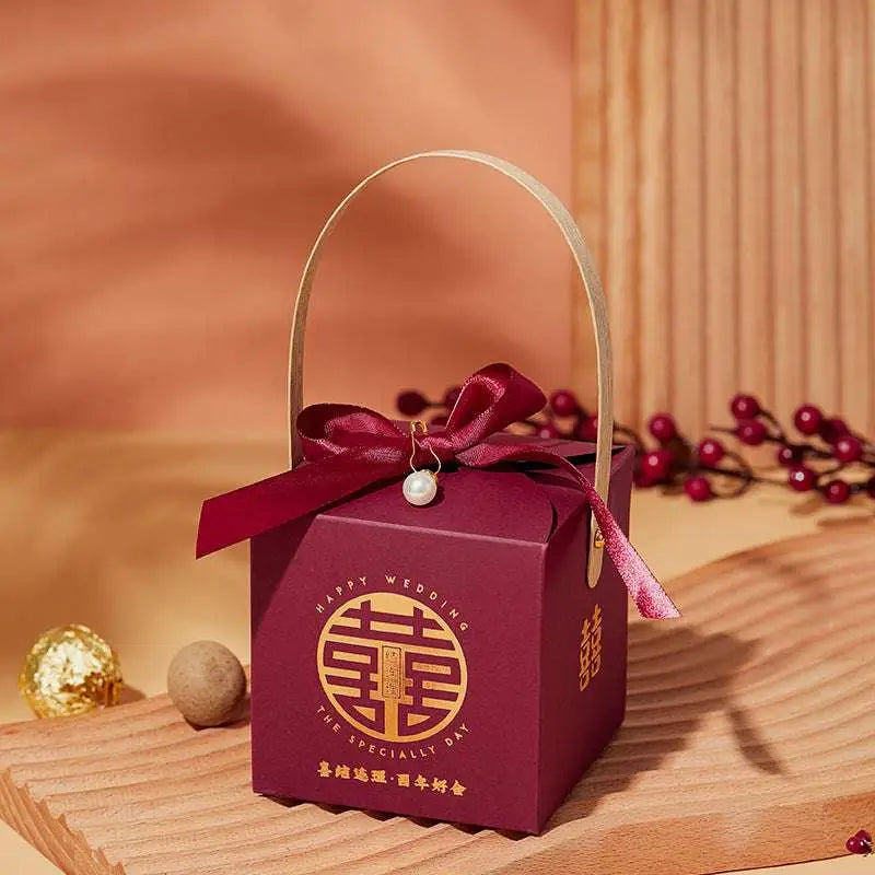 Maroon minimalist wedding candy gift box with gold handle featuring a ribbon bow and pearl charm for a fashion simple look
