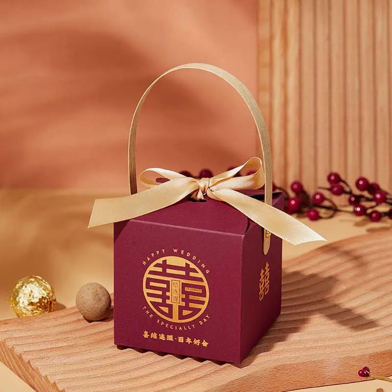 Maroon minimalist wedding candy gift box with gold handle embossed with double happiness symbol in gold bow