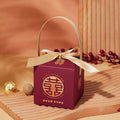 Maroon minimalist wedding candy gift box with gold handle and bow featuring intricate golden Chinese characters and happy wedding text