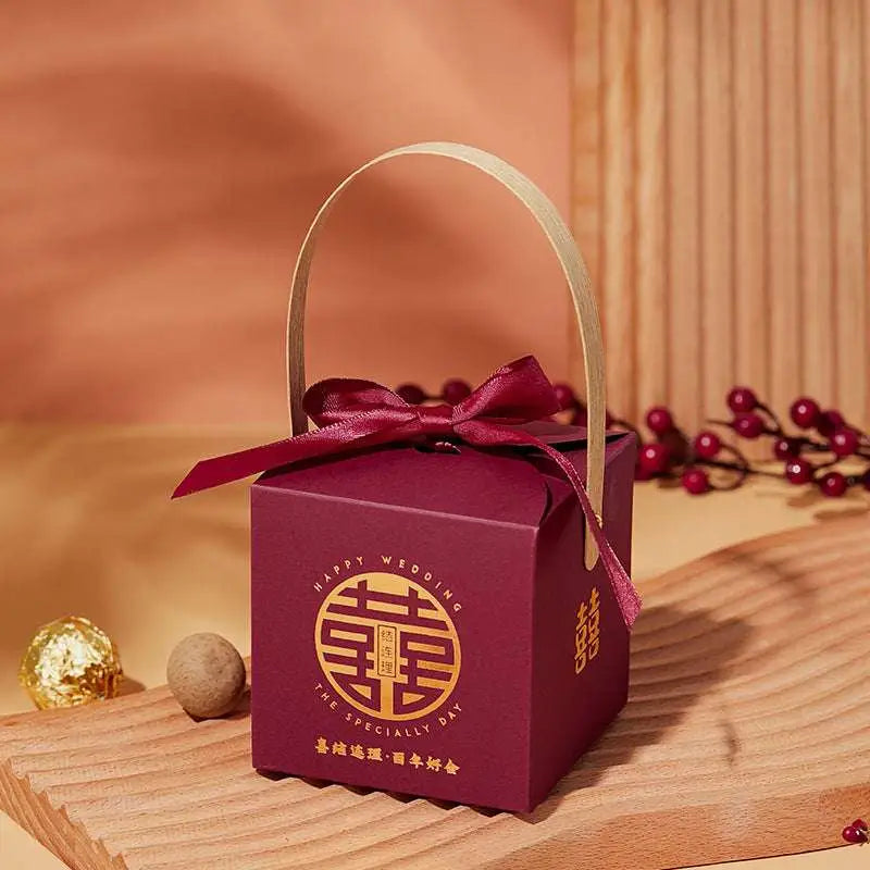 Maroon minimalist wedding candy gift box with gold handle ribbon bow and embossed golden double happiness symbol