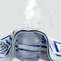 A clear glass tumbler wrapped in a blue and white towel beside a men’s cotton striped boxer set