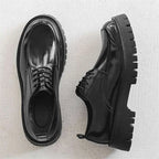 Men’s casual leather shoes in black patent leather with glossy finish, red stitching, and chunky textured soles