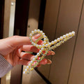 A gold shark clip with white pearls and clear crystals featuring an elegant bow design for korean elegant temperament